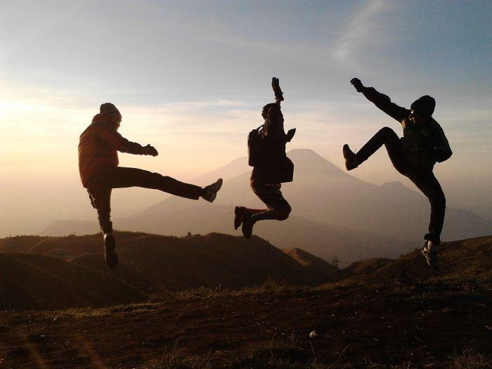 Symbolbild: Drei Jugendliche springen vor einem Bergpanorama in die Luft